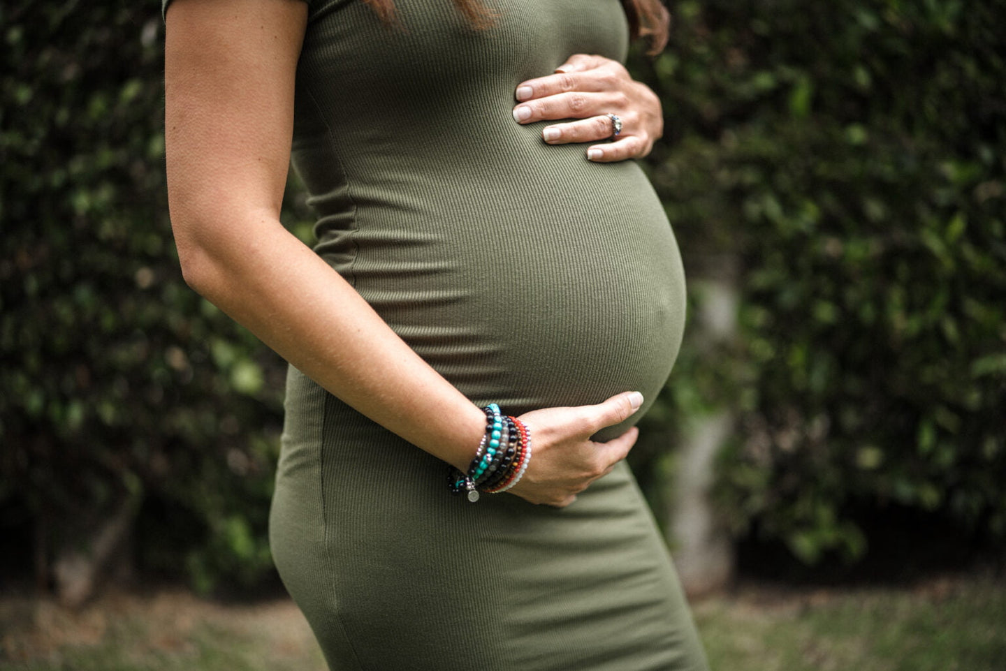 A close up shot of a woman holding her pregnant belly