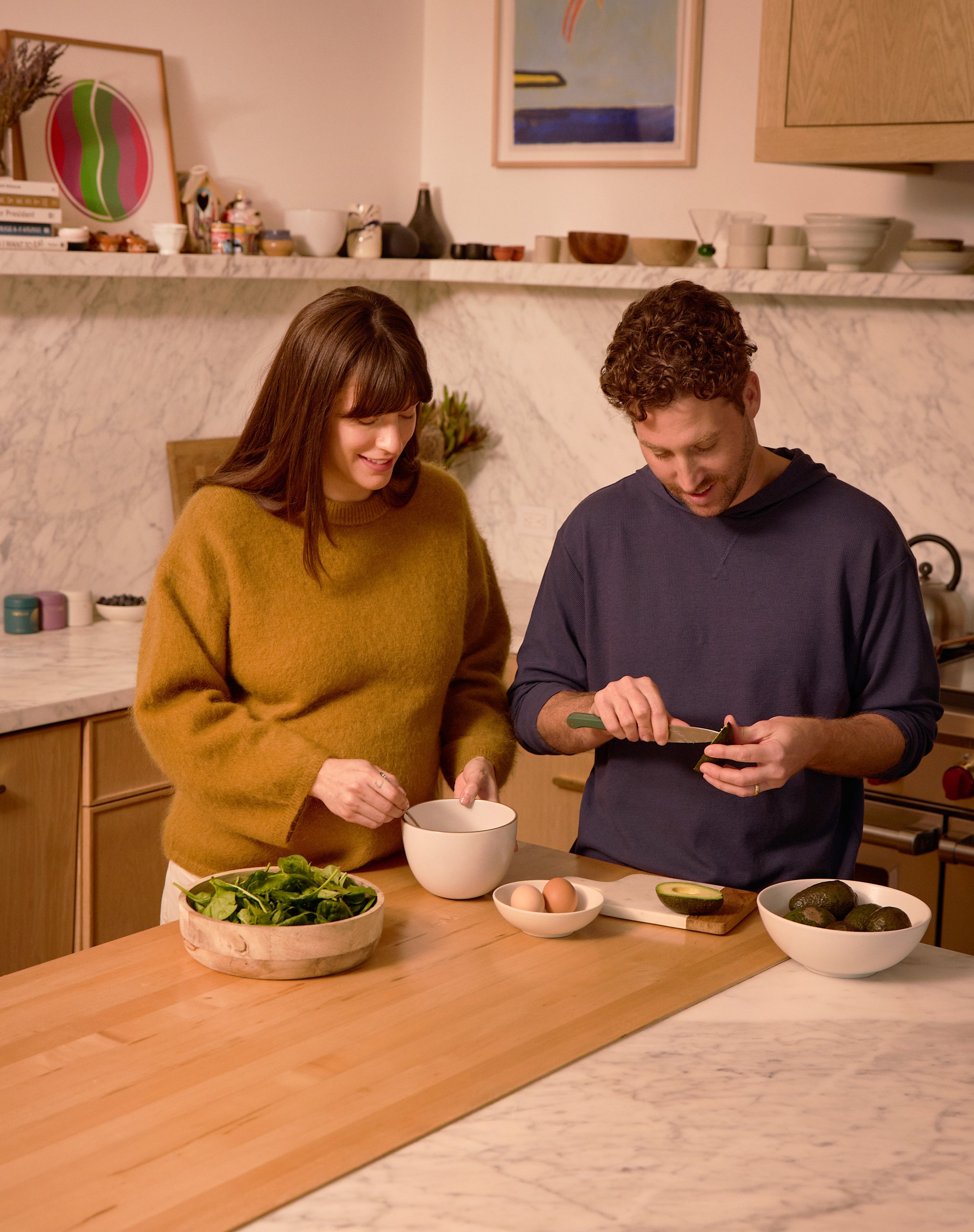 pregnant woman and husband making a meal in their kitchen - WeNatal prenatal