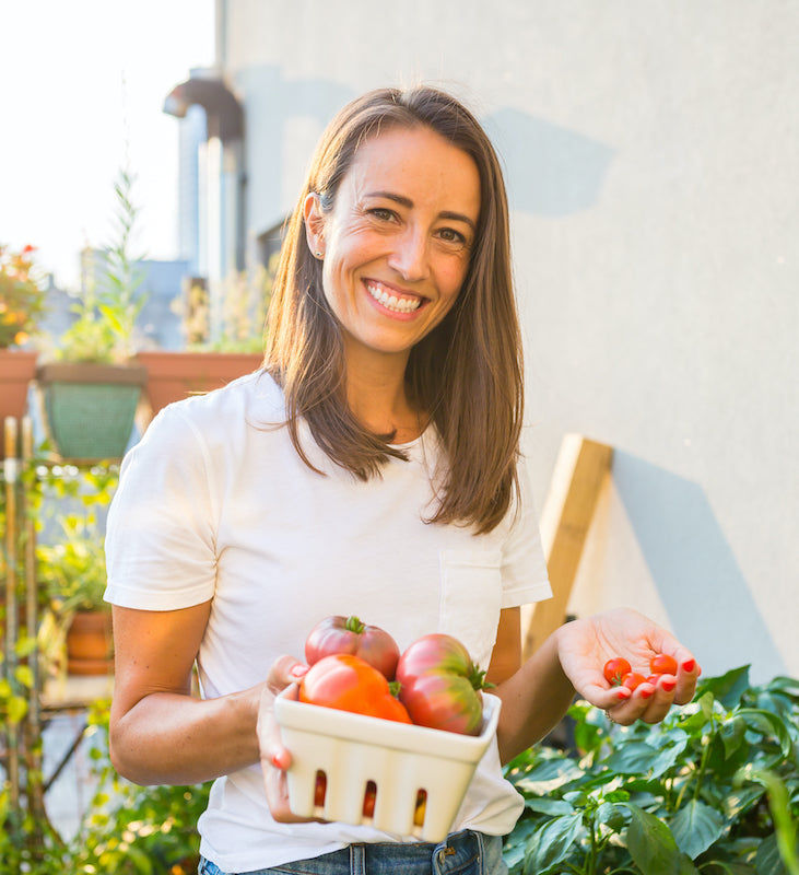 A smiling woman holding a basket of tomatoes, symbolizing fresh, natural foods. Perfect for highlighting WeNatal's focus on health and wellness products.