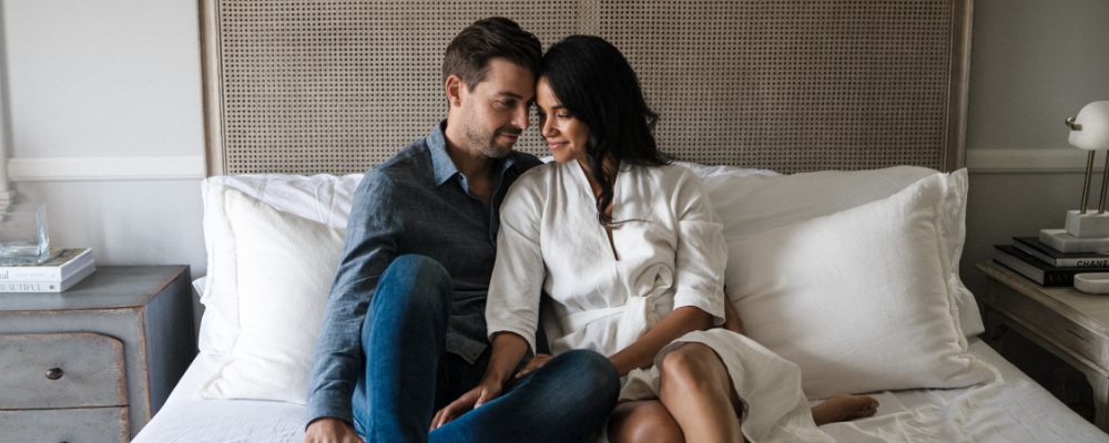 man and woman sitting on bed