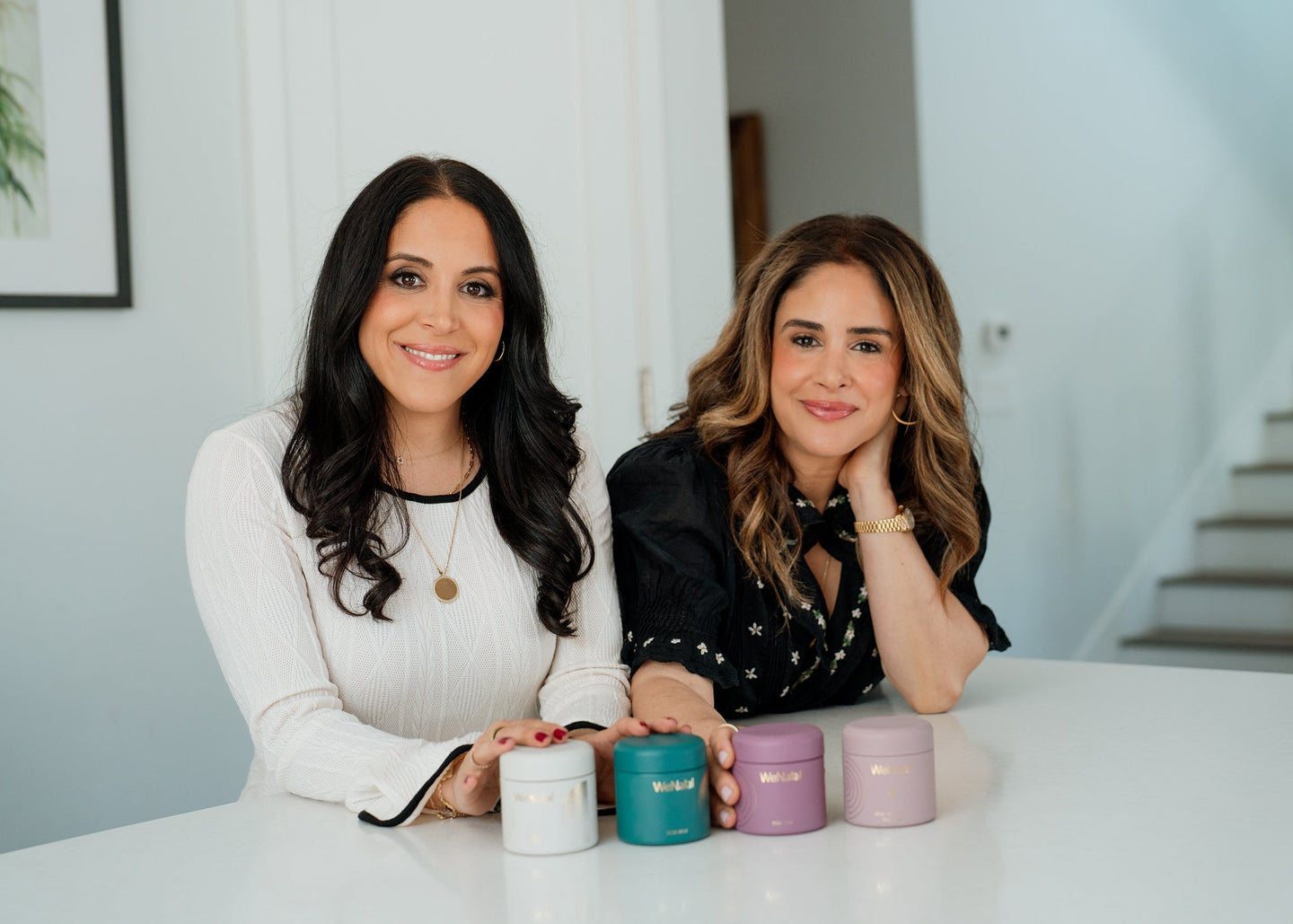 two best friends in kitchen holding glass jars of supplements - WeNatal prenatals