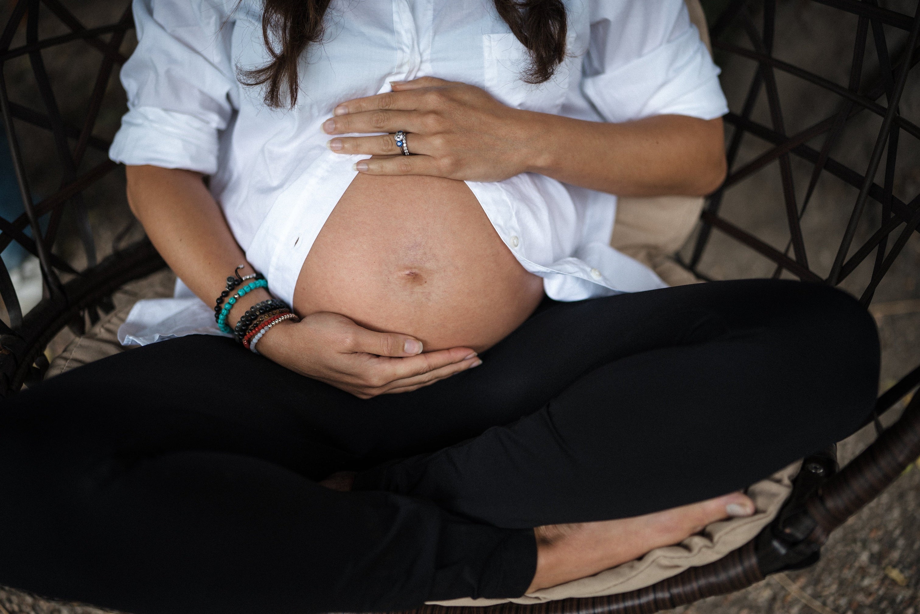 woman holding her pregnant belly - the link between oral health and pregnancy - oral microbiome - WeNatal