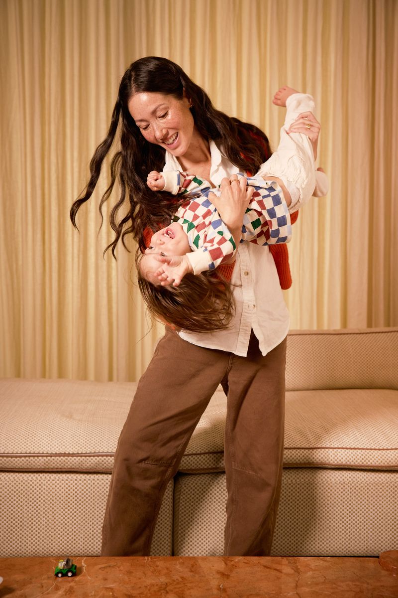 mother holding toddler playfully in living room with them both smiling and having fun - WeNatal prenatal - inositol conversation