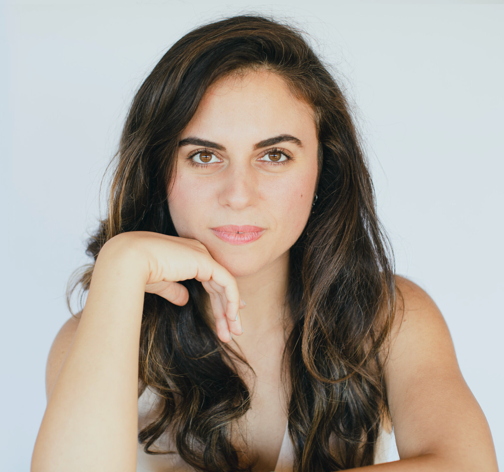 Portrait of a woman with long hair and hand on chin, representing thoughtful contemplation, aligning with WeNatal's nurturing and wellness-focused ethos.