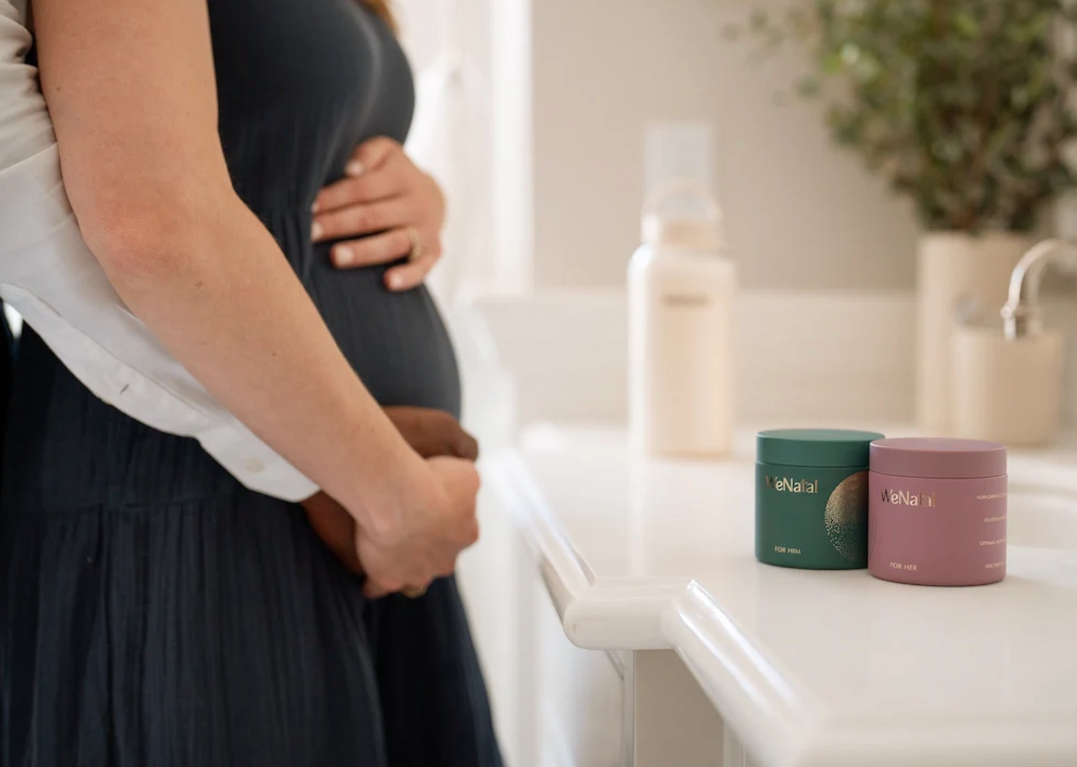 Pregnant woman holding a baby, surrounded by prenatal vitamins and supplement containers, representing WeNatal's product range for prenatal care