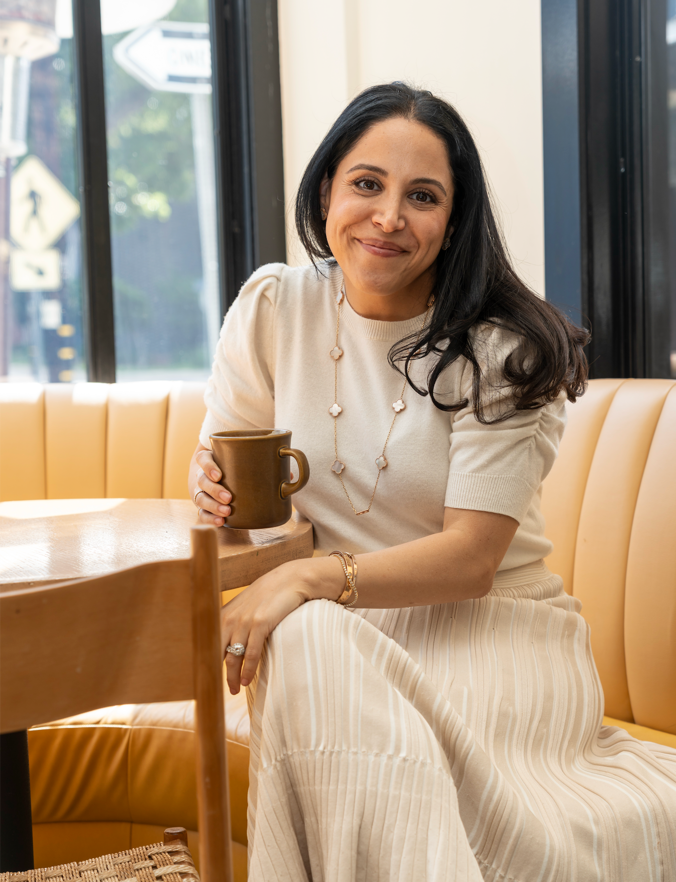 Vida Delrahim, WeNatal Co-founder, sitting in a cafe with a cup of coffee - WeNatal prenatal