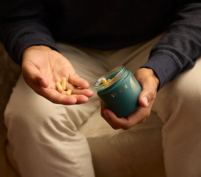 Person holding WeNatal For Him Welcome Kit jar and capsules, highlighting prenatal supplement for daily nutrient support and fertility, essential for men's prenatal nutrition
