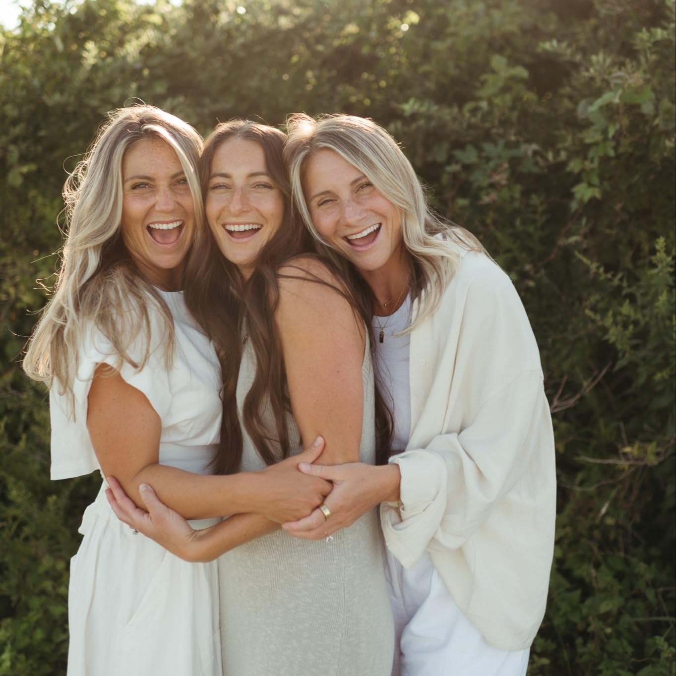 three sisters hugging and laughing 