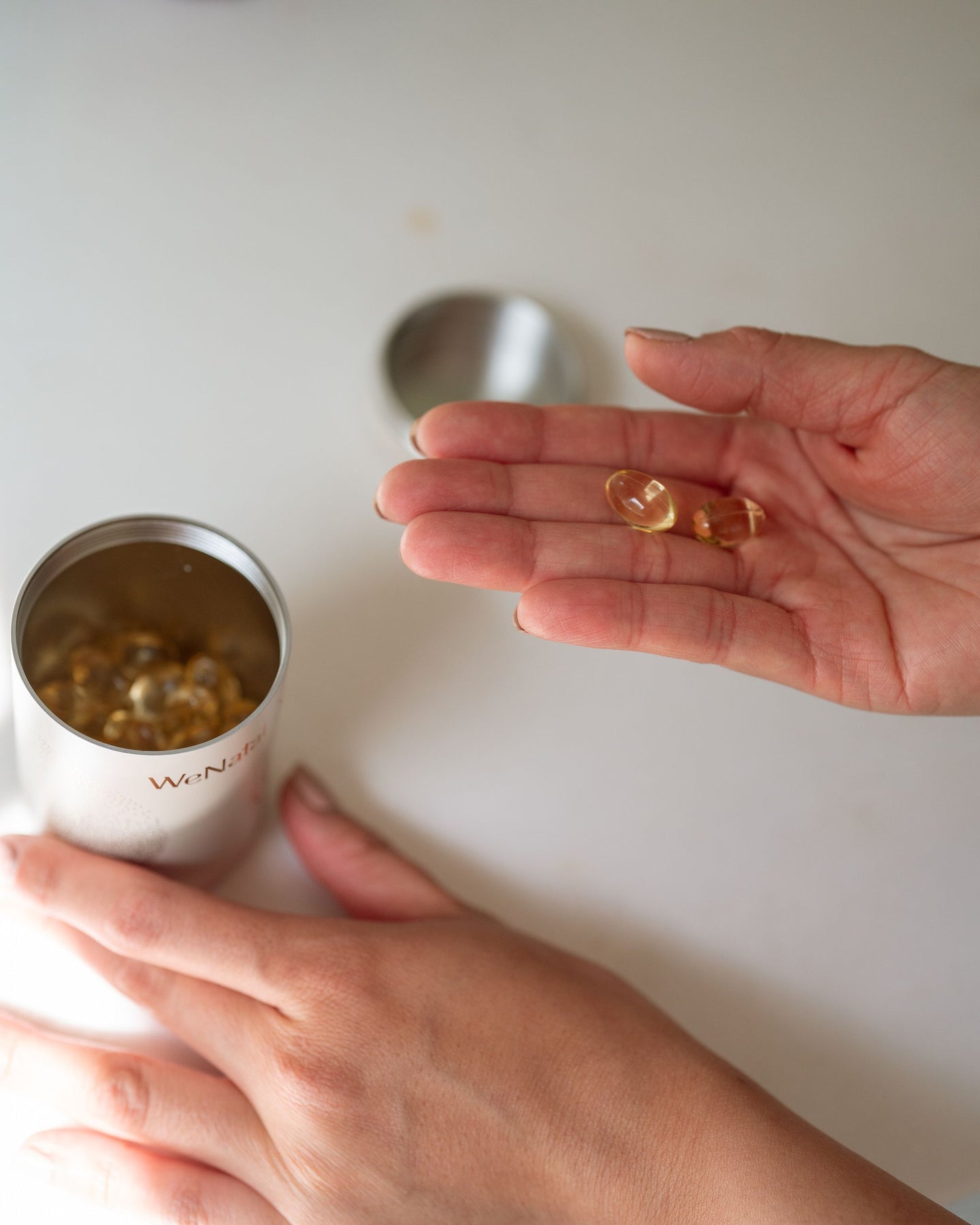 hand holding wenatal fish oil capsules 