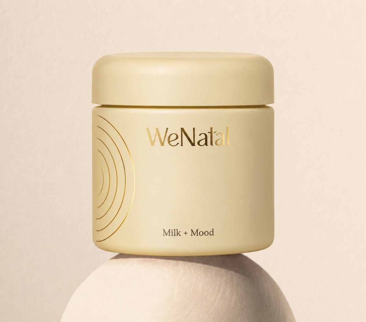A WeNatal Milk + Mood jar perched on a rounded pedestal
