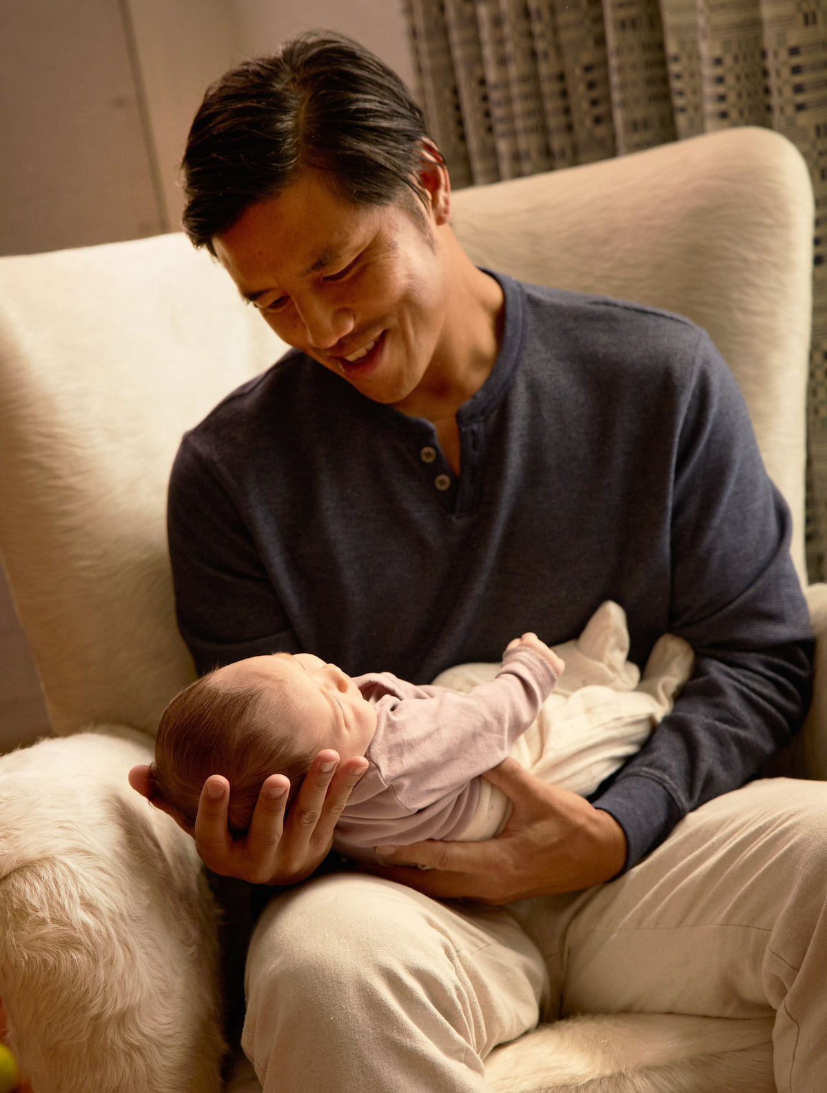 Man holding a baby in his arms on a couch