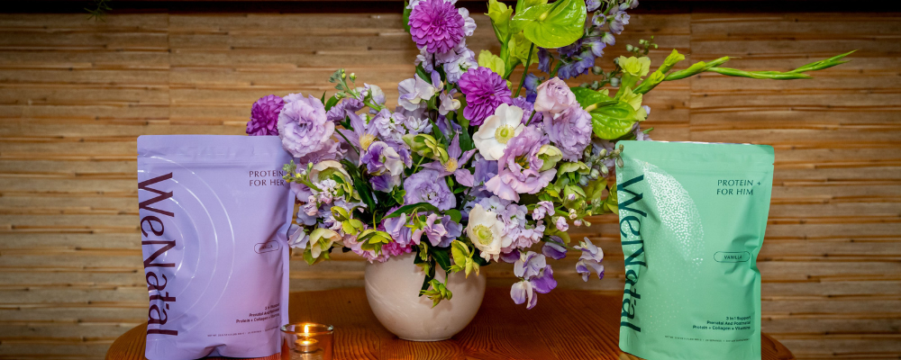 Two WeNata packages on a wooden surface with a vase of flowers in the center.