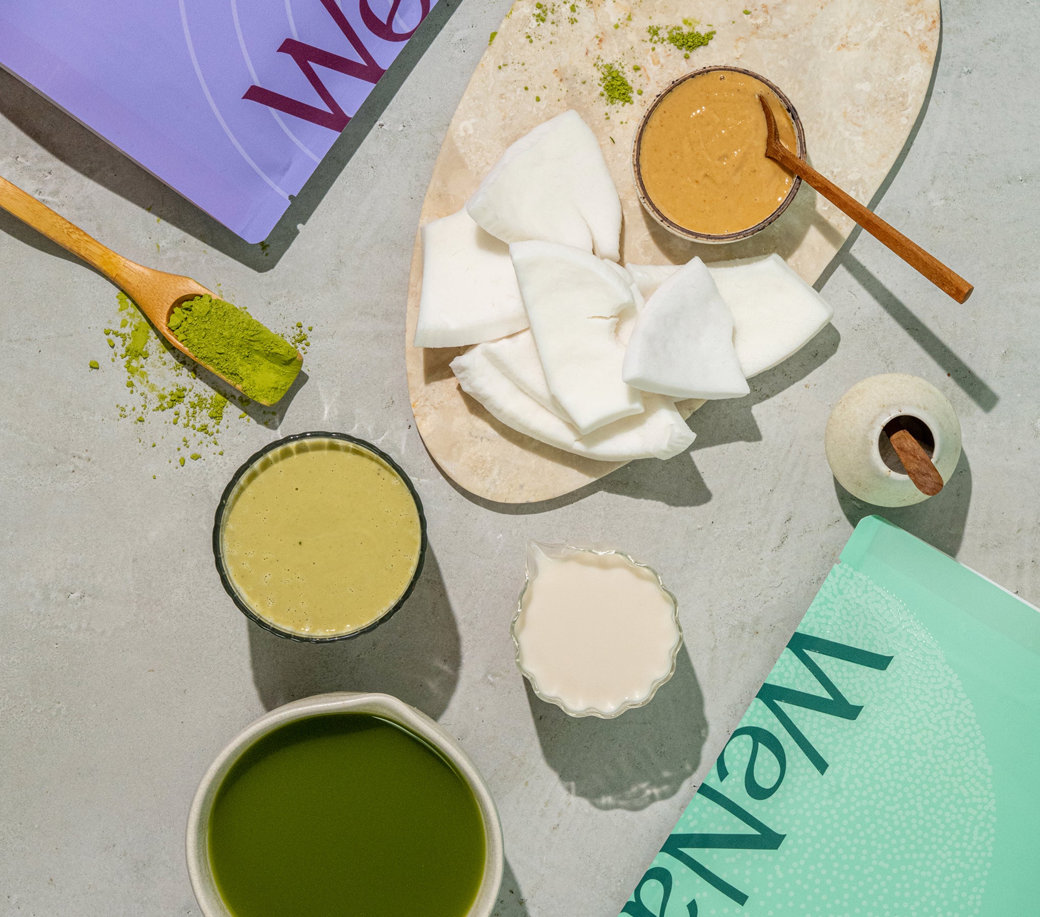 Flat-lay of WeNatal Prenatal Protein+ Together components, including matcha powder, prepared drink, plant-milk, nut butter, and branded boxes, emphasizing prenatal nutrition and daily nutrient support