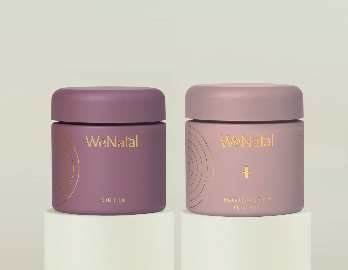 WeNatal for Her & Egg Quality + Duo Welcome Kit jars, embodying a premium women's supplement line, displayed on white cylinders against a minimalist background.