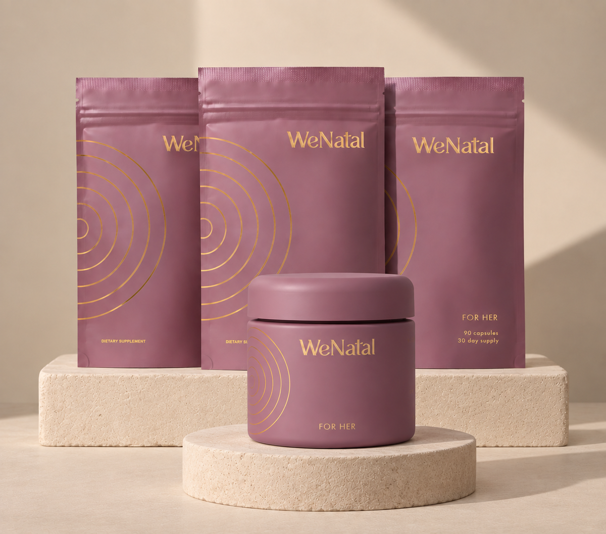 WeNatal For Her 90-day welcome kit: three pouches and a jar displayed on stone pedestals
